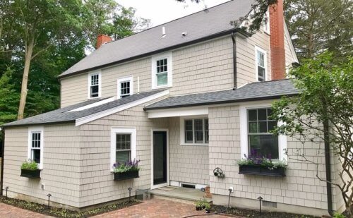 Installer fastening Hardie Plank boards above a window